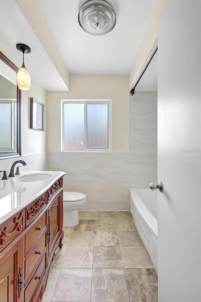 3065 Merrill Ave, Clearwater, FL 33759 - full bath with tile walls, vanity, toilet, shower / washtub combination, and a wainscoted wall