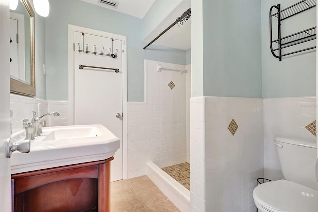 3065 Merrill Ave, Clearwater, FL 33759 - full bathroom with tile walls, toilet, tiled shower, vanity, and tile patterned flooring