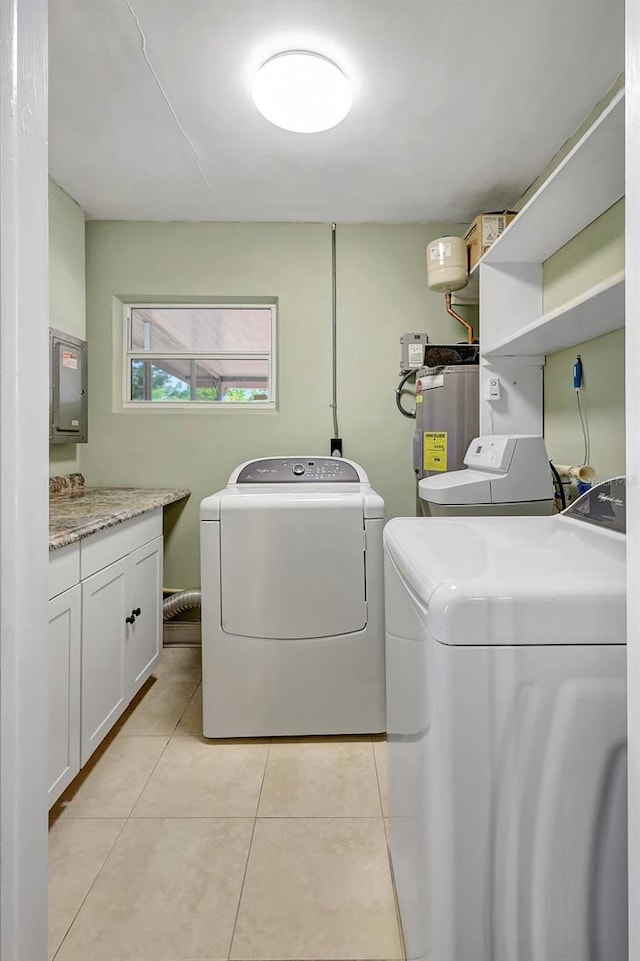 3065 Merrill Ave, Clearwater, FL 33759 - laundry room with separate washer and dryer, water heater, light tile patterned flooring, and cabinet space