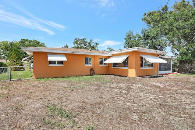 3065 Merrill Ave, Clearwater, FL 33759 - rear view of house with a sunroom, a gate, and stucco siding