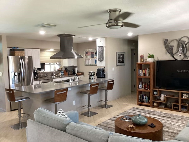 101 Madonna Blvd, Saint Petersburg, FL 33715 - kitchen featuring a peninsula, island exhaust hood, a breakfast bar area, and stainless steel fridge with ice dispenser