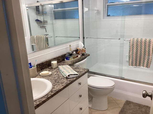 101 Madonna Blvd, Saint Petersburg, FL 33715 - full bathroom with combined bath / shower with glass door, decorative backsplash, vanity, toilet, and tile patterned flooring