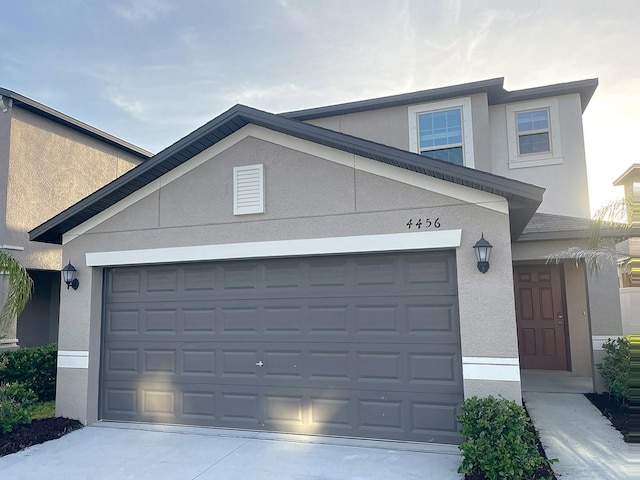 4456 Globe Thistle Dr, Tampa, FL 33619 - traditional home featuring stucco siding, driveway, and an attached garage