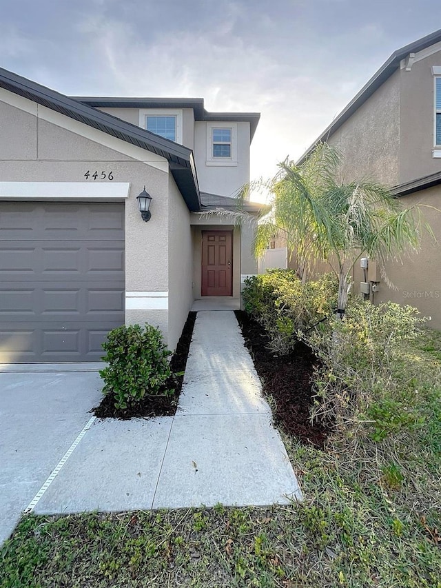 4456 Globe Thistle Dr, Tampa, FL 33619 - entrance to property featuring stucco siding and an attached garage