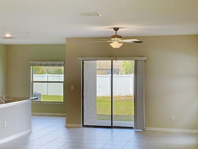 4456 Globe Thistle Dr, Tampa, FL 33619 - empty room with healthy amount of natural light, a ceiling fan, and light tile patterned flooring