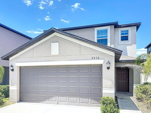 4456 Globe Thistle Dr, Tampa, FL 33619 - view of front of home featuring stucco siding, a garage, and driveway