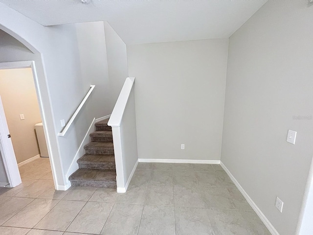 4456 Globe Thistle Dr, Tampa, FL 33619 - stairway featuring arched walkways and tile patterned floors