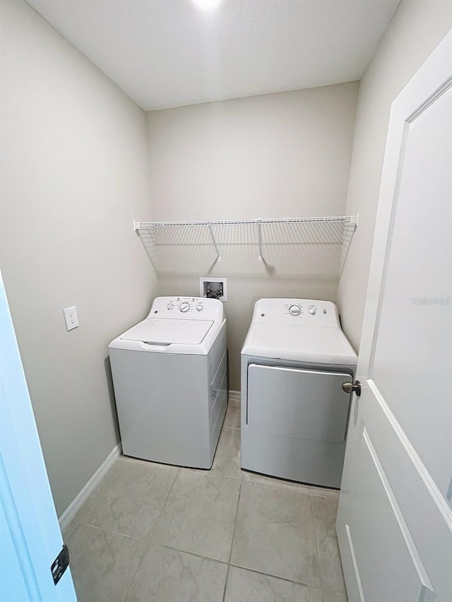 4456 Globe Thistle Dr, Tampa, FL 33619 - laundry area featuring washing machine and dryer and light tile patterned floors