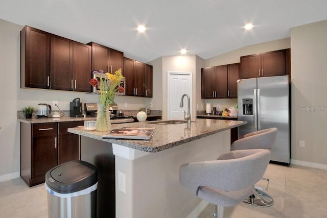 13419 Willow Bluestar Loop, Riverview, FL 33579 - kitchen featuring dark brown cabinets, a breakfast bar, a sink, stainless steel appliances, and baseboards