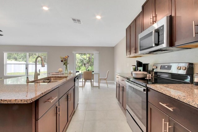 13419 Willow Bluestar Loop, Riverview, FL 33579 - kitchen featuring light stone countertops, a sink, an island with sink, stainless steel appliances, and visible vents