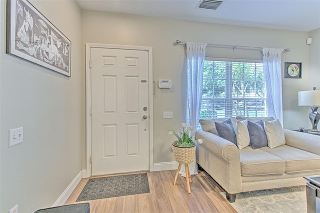foyer featuring light wood-style floors, visible vents, and baseboards