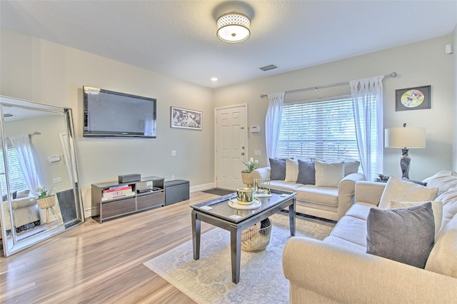 living area featuring visible vents, baseboards, and light wood-type flooring