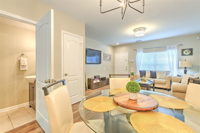 dining space with ceiling fan, light wood-style flooring, and baseboards