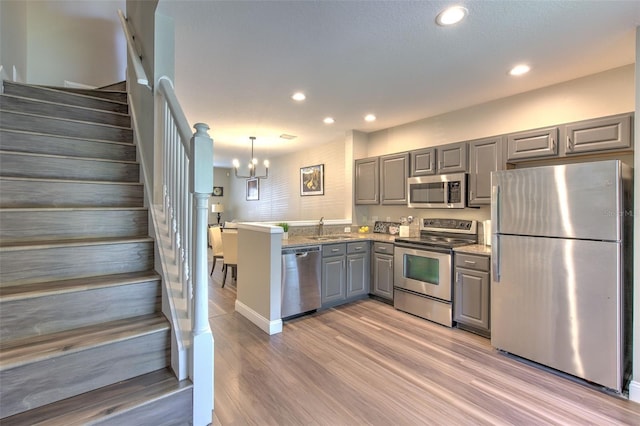 kitchen with recessed lighting, a sink, gray cabinets, a notable chandelier, and appliances with stainless steel finishes