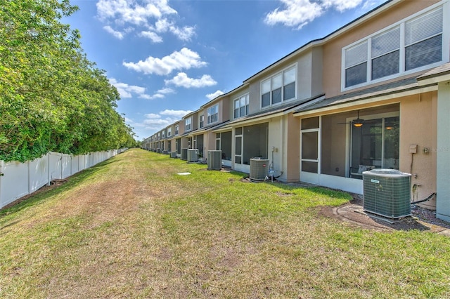 view of yard with central AC and fence