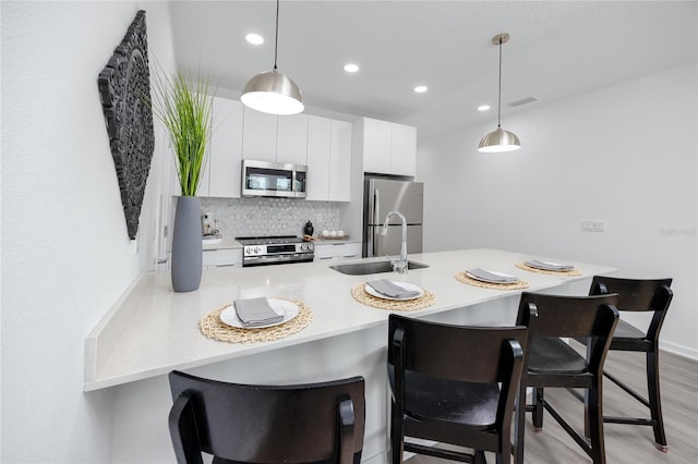 3402 E 28th Ave Unit 6, Tampa, FL 33605 - kitchen with stainless steel appliances, a kitchen breakfast bar, a peninsula, light countertops, and recessed lighting