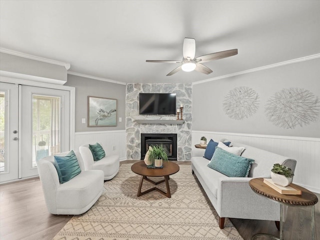 619 2nd St Unit 3, Indian Rocks Beach, FL 33785 - living area featuring crown molding, wainscoting, a ceiling fan, wood finished floors, and a stone fireplace