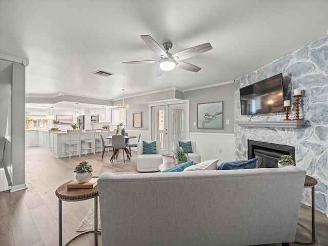 619 2nd St Unit 3, Indian Rocks Beach, FL 33785 - living room featuring a fireplace, ornamental molding, a ceiling fan, wood finished floors, and wainscoting
