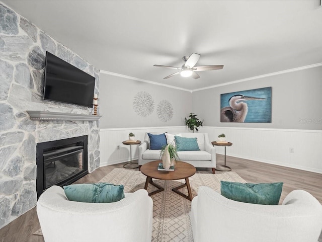 619 2nd St Unit 3, Indian Rocks Beach, FL 33785 - living room with wood finished floors, a fireplace, a wainscoted wall, a ceiling fan, and crown molding