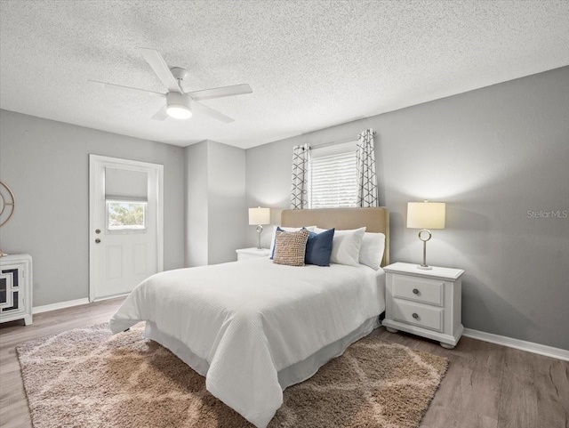 619 2nd St Unit 3, Indian Rocks Beach, FL 33785 - bedroom featuring multiple windows, light wood-style floors, a textured ceiling, and baseboards