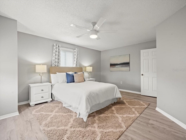 619 2nd St Unit 3, Indian Rocks Beach, FL 33785 - bedroom featuring baseboards, a textured ceiling, wood finished floors, and ceiling fan
