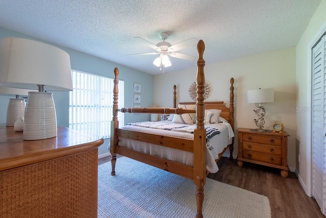 bedroom featuring ceiling fan, baseboards, wood finished floors, and a textured ceiling