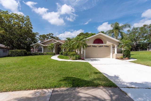 view of front of house featuring stucco siding, concrete driveway, a front yard, and a garage