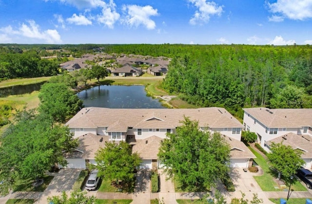 drone / aerial view featuring a forest view, a water view, and a residential view