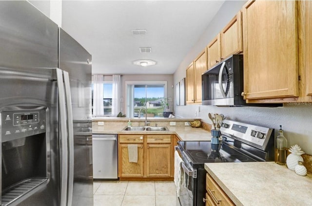 kitchen with stainless steel appliances, light countertops, visible vents, light tile patterned floors, and a sink