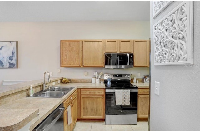 kitchen featuring a peninsula, light countertops, appliances with stainless steel finishes, and a sink