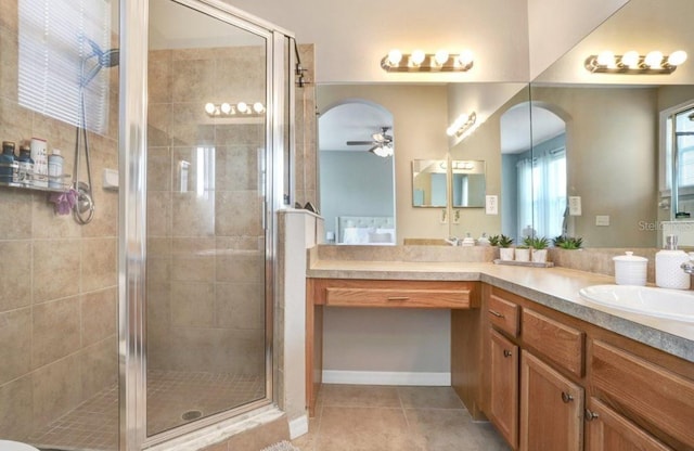 bathroom with vanity, tile patterned flooring, ceiling fan, and a stall shower