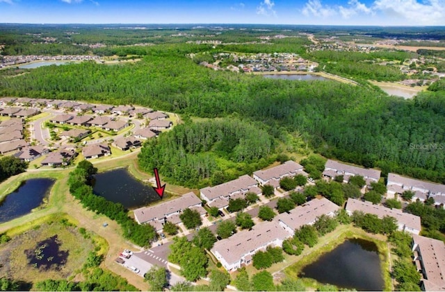 aerial view with a wooded view, a residential view, and a water view