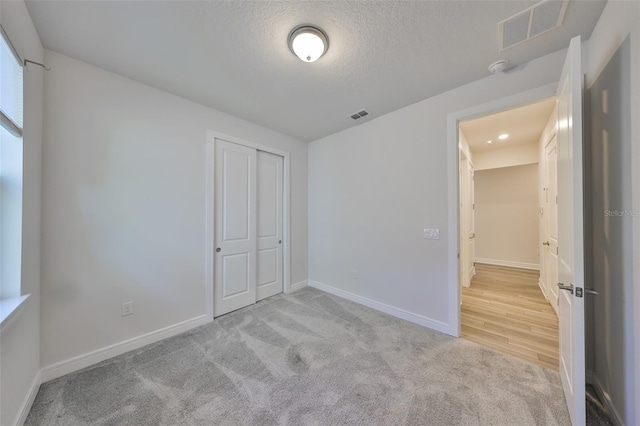 36959 Highland Meadows Ct, Zephyrhills, FL 33542 - unfurnished bedroom with a textured ceiling, carpet flooring, baseboards, and a closet