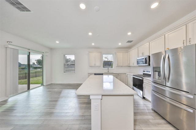 36959 Highland Meadows Ct, Zephyrhills, FL 33542 - kitchen with appliances with stainless steel finishes, a center island, recessed lighting, plenty of natural light, and light wood-type flooring