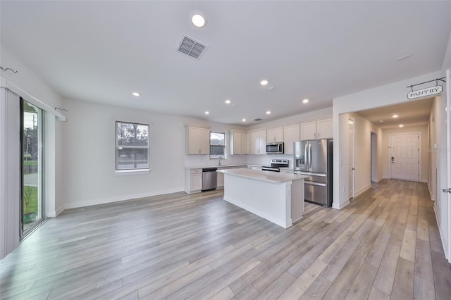 36959 Highland Meadows Ct, Zephyrhills, FL 33542 - kitchen featuring appliances with stainless steel finishes, light countertops, recessed lighting, light wood-type flooring, and a kitchen island