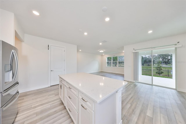 36959 Highland Meadows Ct, Zephyrhills, FL 33542 - kitchen with stainless steel refrigerator with ice dispenser, light wood-style floors, white cabinetry, baseboards, and a kitchen island