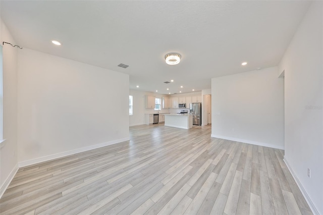 36959 Highland Meadows Ct, Zephyrhills, FL 33542 - unfurnished living room with light wood-style floors, recessed lighting, and baseboards