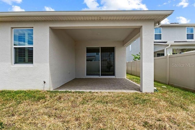 2477 Water Willow Dr, Lutz, FL 33558 - rear view of house with a yard, a patio area, stucco siding, and fence
