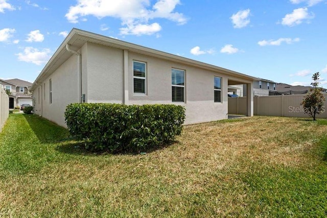 2477 Water Willow Dr, Lutz, FL 33558 - back of house featuring fence, a lawn, and stucco siding