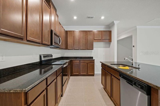 2477 Water Willow Dr, Lutz, FL 33558 - kitchen featuring crown molding, dark stone countertops, a sink, appliances with stainless steel finishes, and visible vents