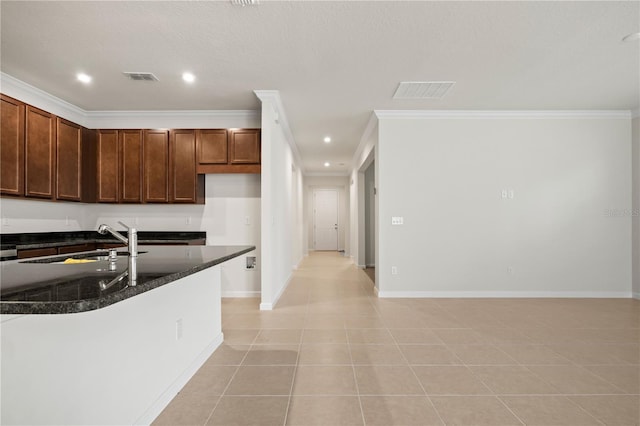 2477 Water Willow Dr, Lutz, FL 33558 - kitchen with recessed lighting, visible vents, light tile patterned floors, a sink, and crown molding
