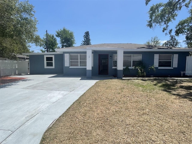 ranch-style house with fence, driveway, and stucco siding
