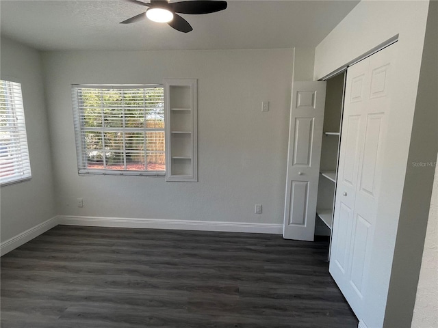 empty room with dark wood-style flooring, ceiling fan, and baseboards