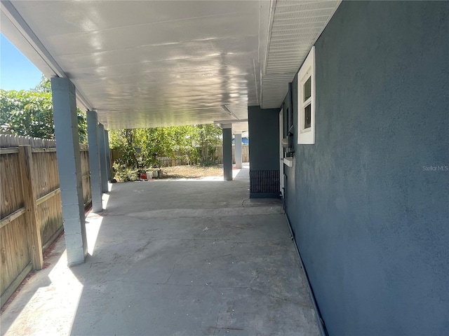 view of patio / terrace featuring fence and an attached carport