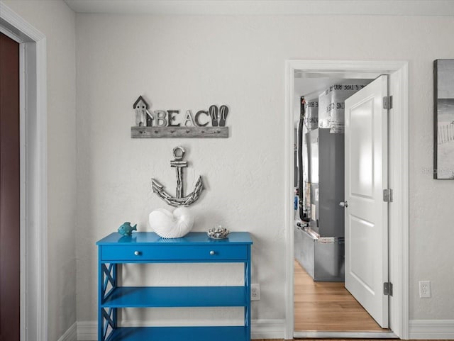 hallway featuring baseboards and wood finished floors