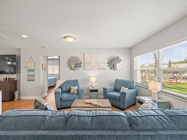 living room featuring visible vents, wood finished floors, and baseboards