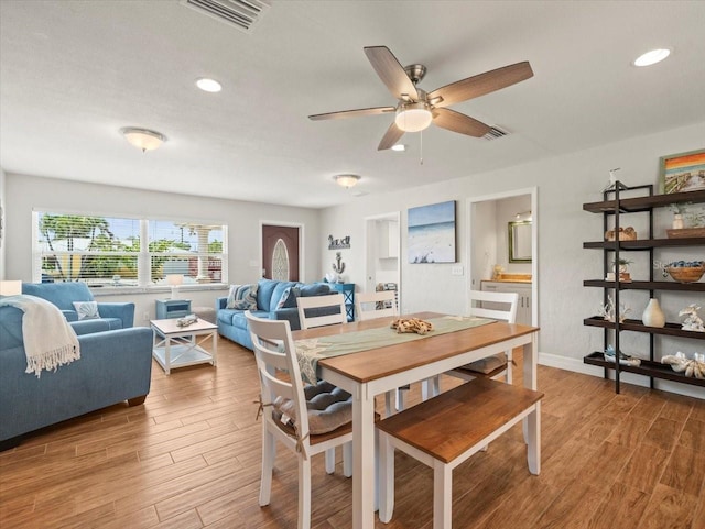 dining space featuring baseboards, ceiling fan, visible vents, and wood finished floors