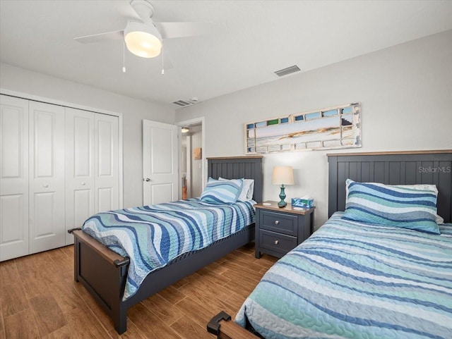 bedroom featuring a closet, visible vents, wood finished floors, and ceiling fan
