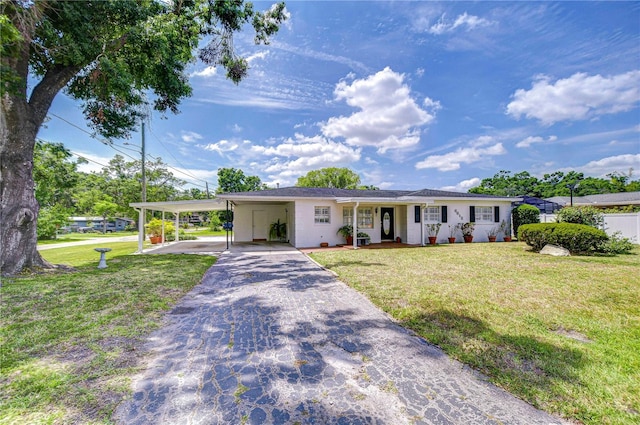 ranch-style house featuring driveway, a front yard, and an attached carport