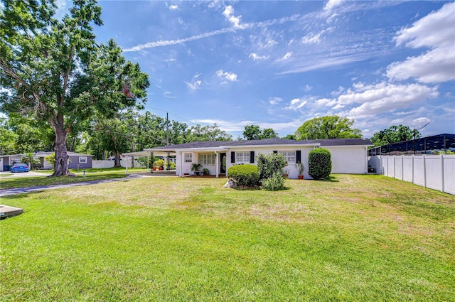 view of front of property featuring a carport, concrete driveway, stucco siding, fence, and a front lawn